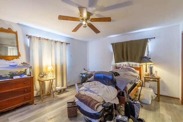 bedroom with a ceiling fan, baseboards, and wood finished floors