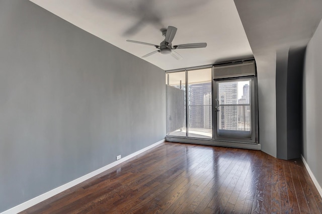 spare room with ceiling fan, dark hardwood / wood-style floors, and floor to ceiling windows