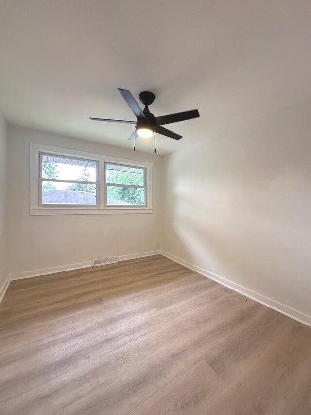 empty room with light wood-type flooring, ceiling fan, and a healthy amount of sunlight