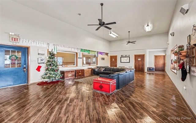 living room with a high ceiling, dark hardwood / wood-style floors, and ceiling fan