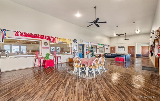 dining room featuring wood-type flooring, a towering ceiling, and ceiling fan