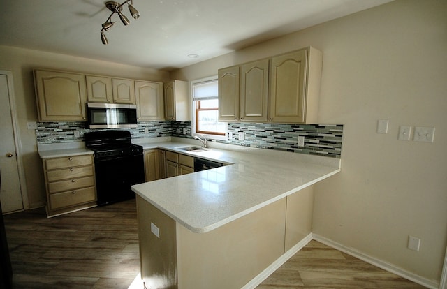 kitchen featuring black range with electric stovetop, kitchen peninsula, and hardwood / wood-style flooring