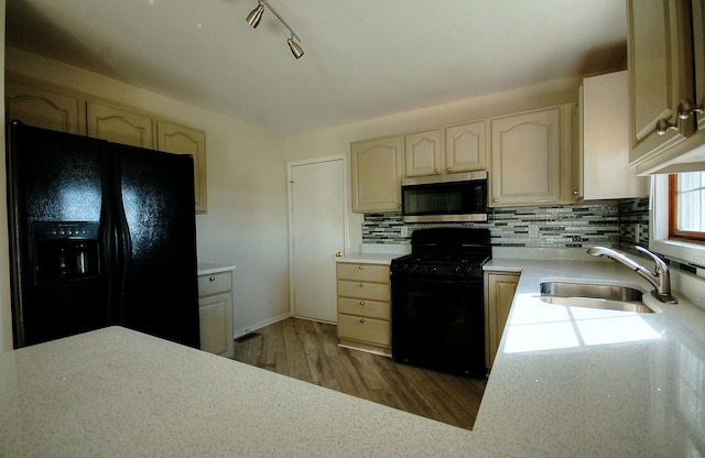 kitchen featuring black appliances, sink, decorative backsplash, rail lighting, and wood-type flooring