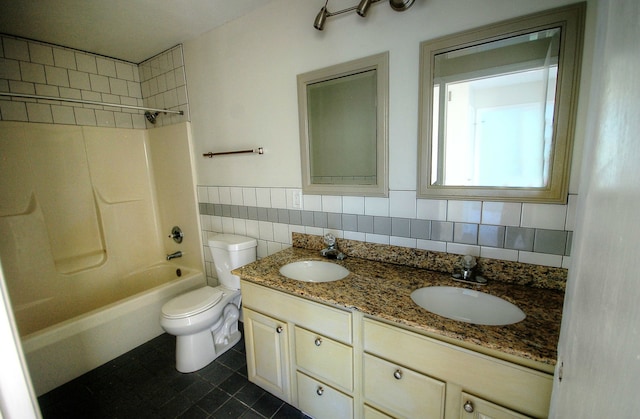 full bathroom with double vanity, tiled shower / bath combo, toilet, tile walls, and decorative backsplash