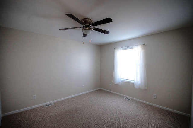 spare room with a ceiling fan, carpet flooring, visible vents, and baseboards