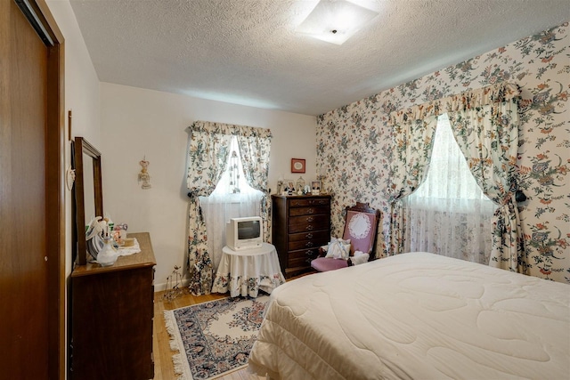 bedroom featuring a closet, hardwood / wood-style floors, and a textured ceiling