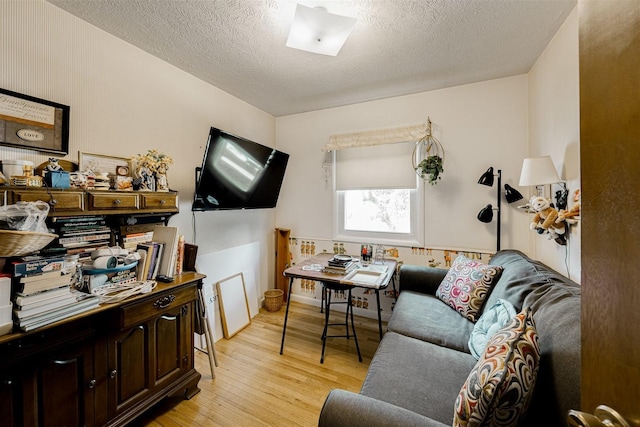 living room featuring light hardwood / wood-style flooring and a textured ceiling