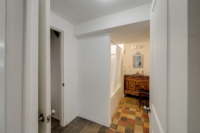 hall featuring sink and a textured ceiling