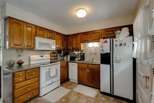 kitchen featuring sink, white appliances, and decorative backsplash