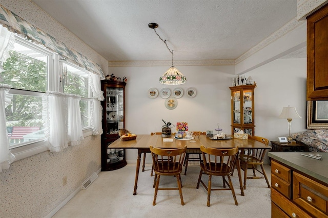 dining room with light carpet and a textured ceiling