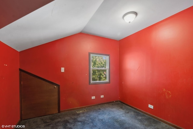 carpeted spare room featuring lofted ceiling