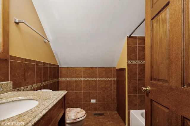 full bathroom with toilet, tile patterned flooring, vaulted ceiling, and tile walls