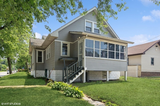 rear view of house with a yard and a sunroom