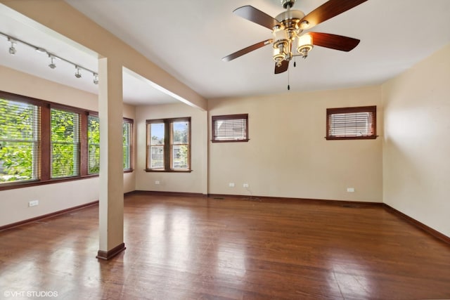 empty room featuring plenty of natural light, dark wood-type flooring, and ceiling fan