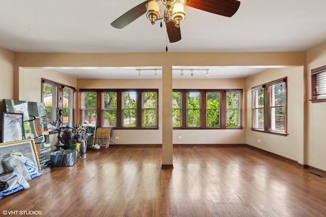 interior space featuring hardwood / wood-style floors, track lighting, and ceiling fan