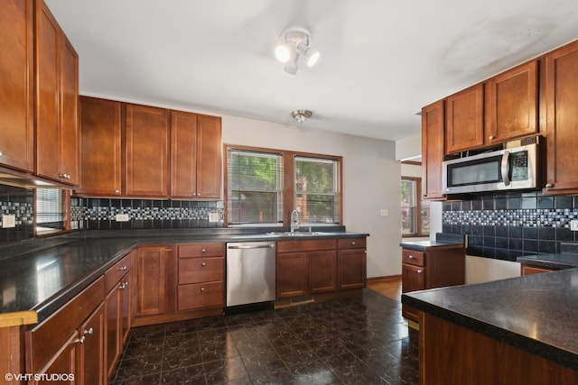 kitchen with backsplash, sink, and appliances with stainless steel finishes