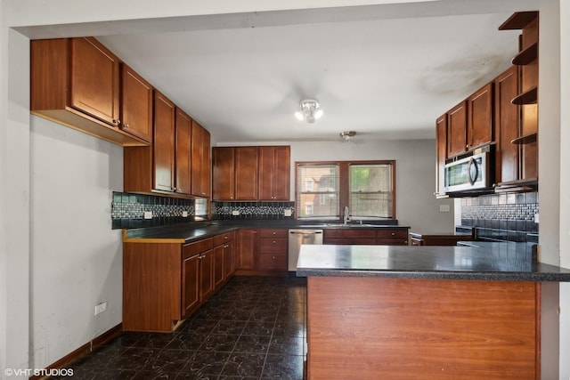 kitchen with kitchen peninsula, decorative backsplash, sink, and stainless steel appliances