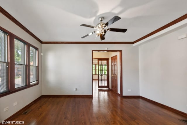 spare room featuring a healthy amount of sunlight, dark wood-type flooring, and crown molding