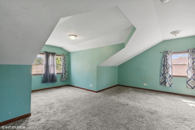 additional living space featuring carpet and lofted ceiling