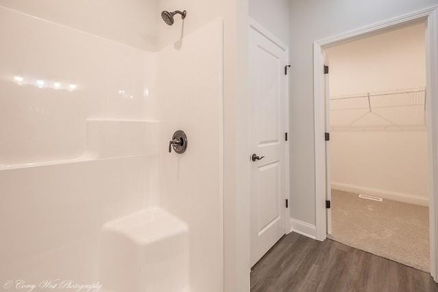 bathroom featuring wood-type flooring and walk in shower