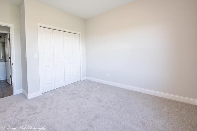 unfurnished bedroom featuring carpet floors and a closet