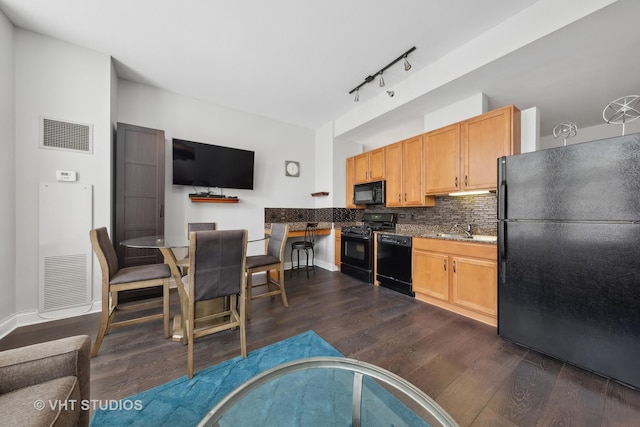 kitchen with sink, light brown cabinets, dark hardwood / wood-style floors, decorative backsplash, and black appliances