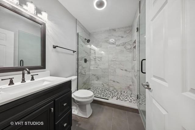 bathroom featuring vanity, an enclosed shower, tile patterned floors, and toilet