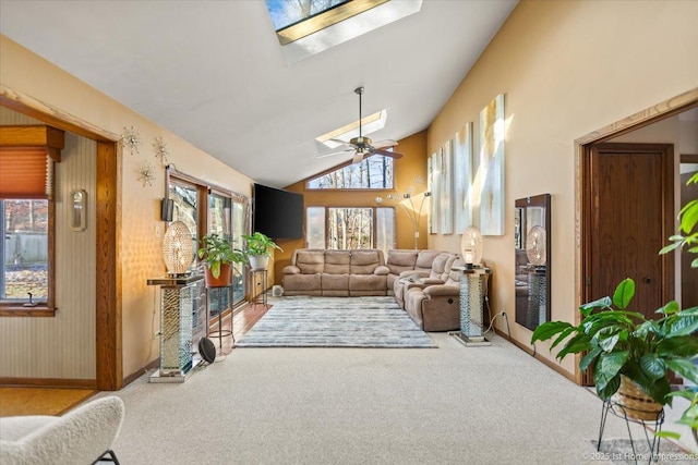 carpeted living room featuring high vaulted ceiling, ceiling fan, and a skylight