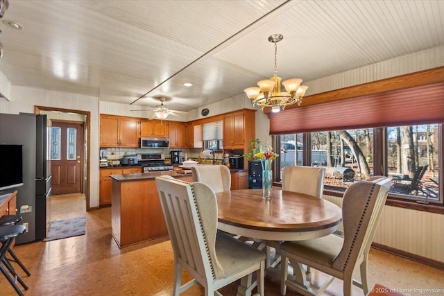 dining room featuring ceiling fan with notable chandelier