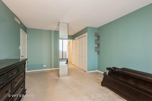 bedroom featuring a closet, light carpet, visible vents, and baseboards