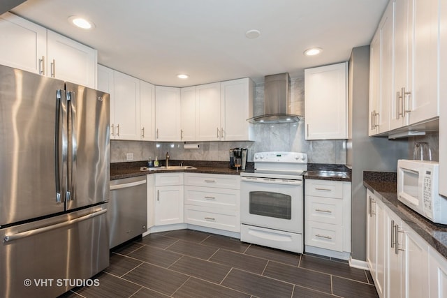 kitchen with stainless steel appliances, wall chimney exhaust hood, a sink, and backsplash