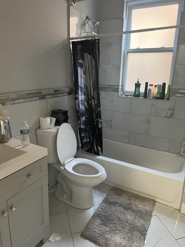 full bathroom with vanity, tile walls, shower / tub combo with curtain, and toilet