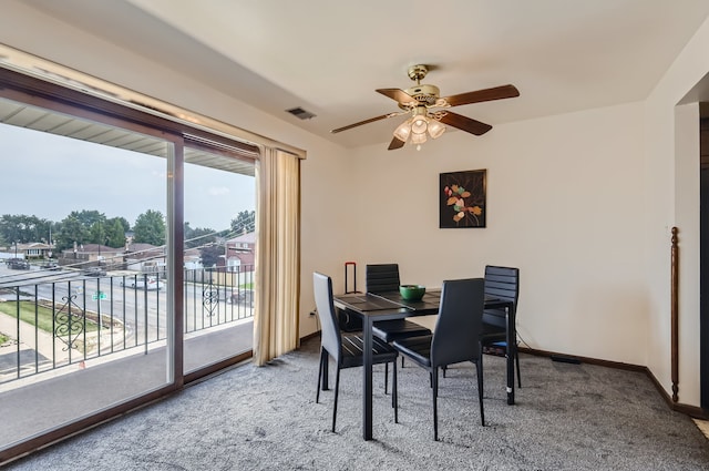 carpeted dining area with ceiling fan