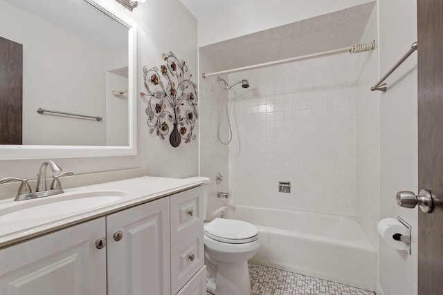 full bathroom featuring vanity, tiled shower / bath, and toilet