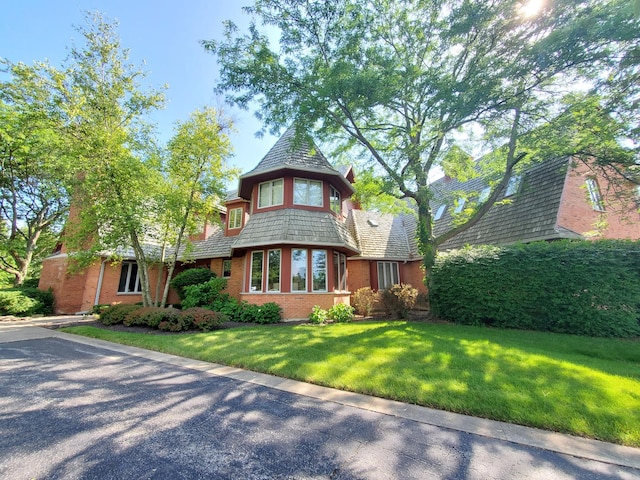 view of front of house featuring brick siding and a front yard