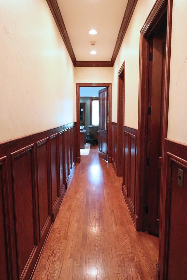 hall featuring light hardwood / wood-style flooring and crown molding