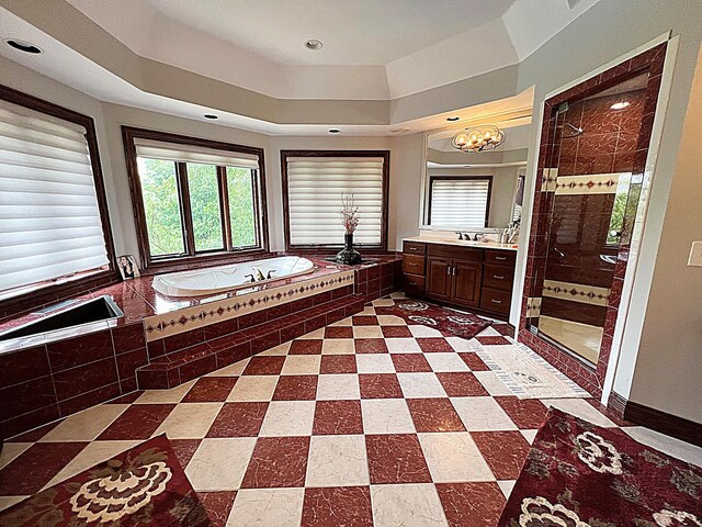 bathroom featuring vanity, separate shower and tub, and a notable chandelier