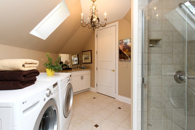 clothes washing area featuring a chandelier, light tile patterned flooring, washer and dryer, and a skylight