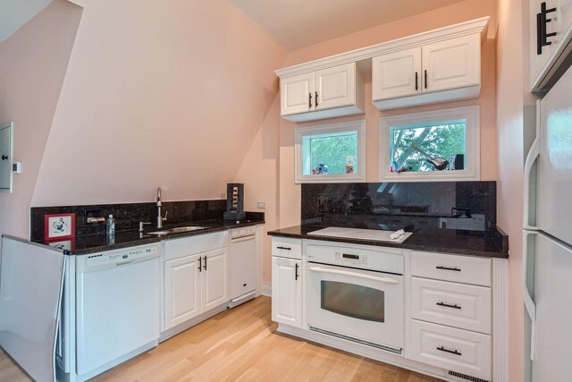 kitchen with tasteful backsplash, white appliances, sink, light hardwood / wood-style floors, and white cabinetry