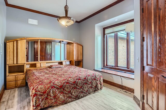 bedroom featuring light hardwood / wood-style floors and ornamental molding