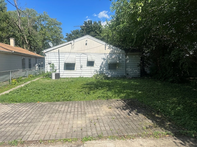 exterior space featuring central air condition unit and a yard