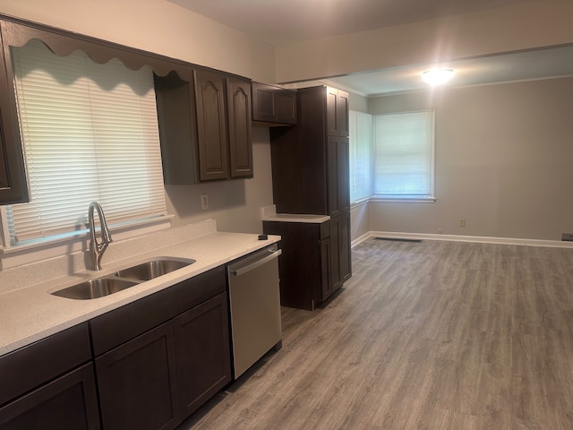 kitchen featuring sink, stainless steel dishwasher, light hardwood / wood-style flooring, and dark brown cabinetry