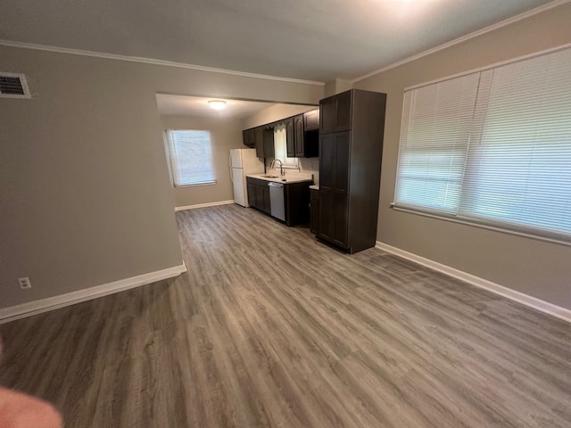 unfurnished living room with wood-type flooring, crown molding, and sink