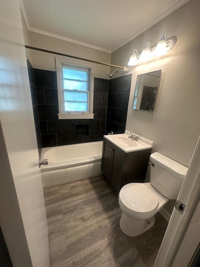 full bathroom featuring crown molding, tiled shower / bath combo, vanity, toilet, and wood-type flooring