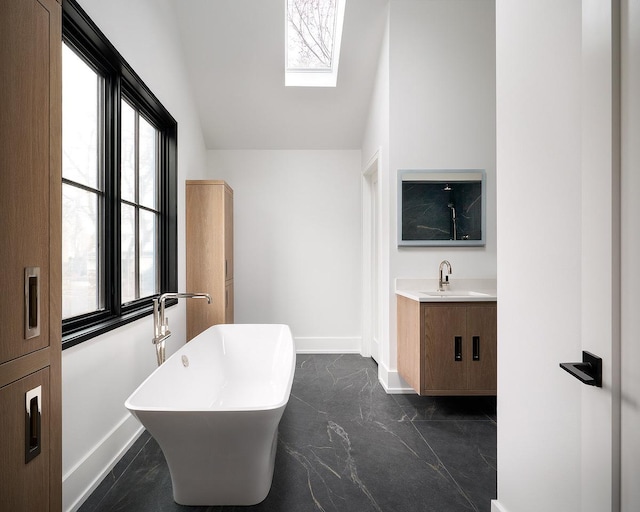 bathroom featuring a wealth of natural light, a bath, lofted ceiling, and vanity