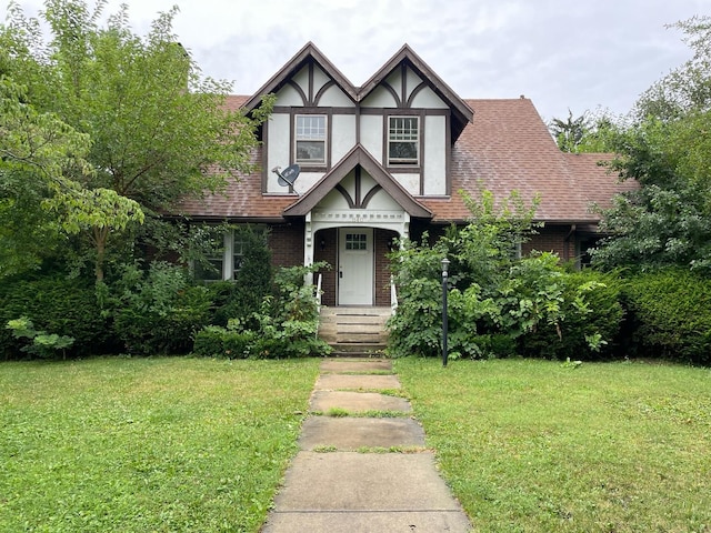 tudor-style house featuring a front lawn