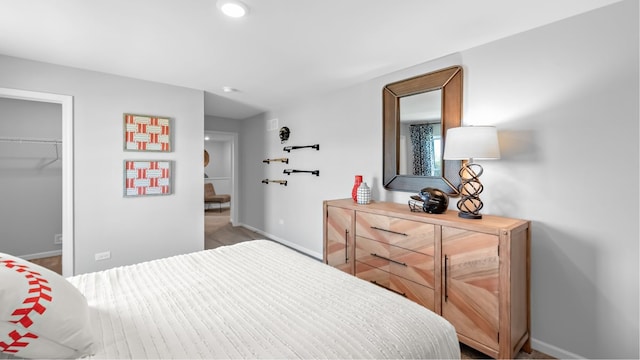 bedroom featuring a closet, hardwood / wood-style floors, and a walk in closet