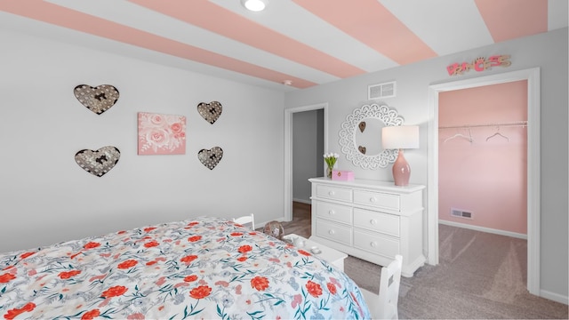 bedroom featuring a walk in closet, a closet, and carpet flooring