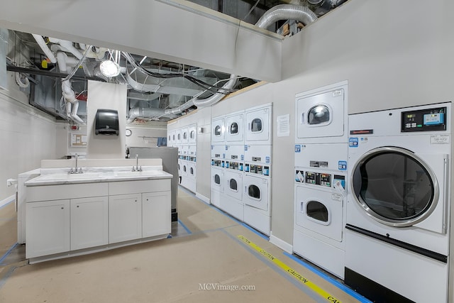 washroom with washer and dryer, stacked washer / dryer, cabinet space, and a sink