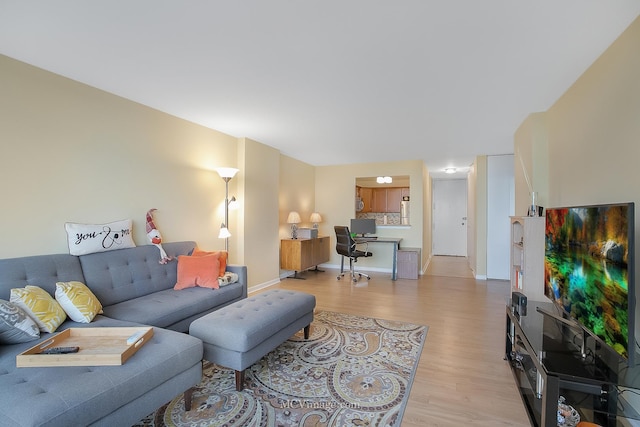 living area with light wood-style floors and baseboards